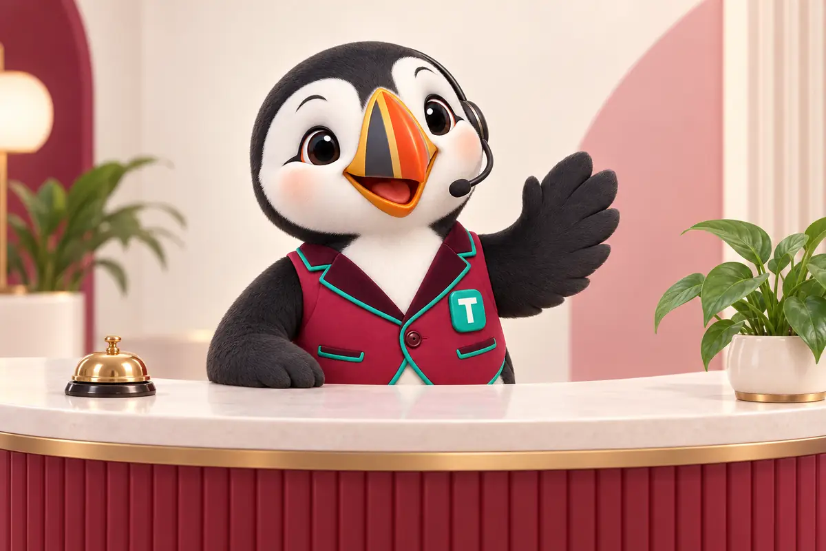 Tolly waving from behind a reception desk with a bell and a plant