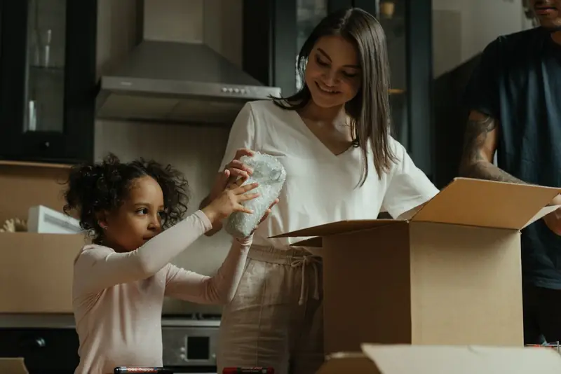 A family unpacking boxes together in their new kitchen