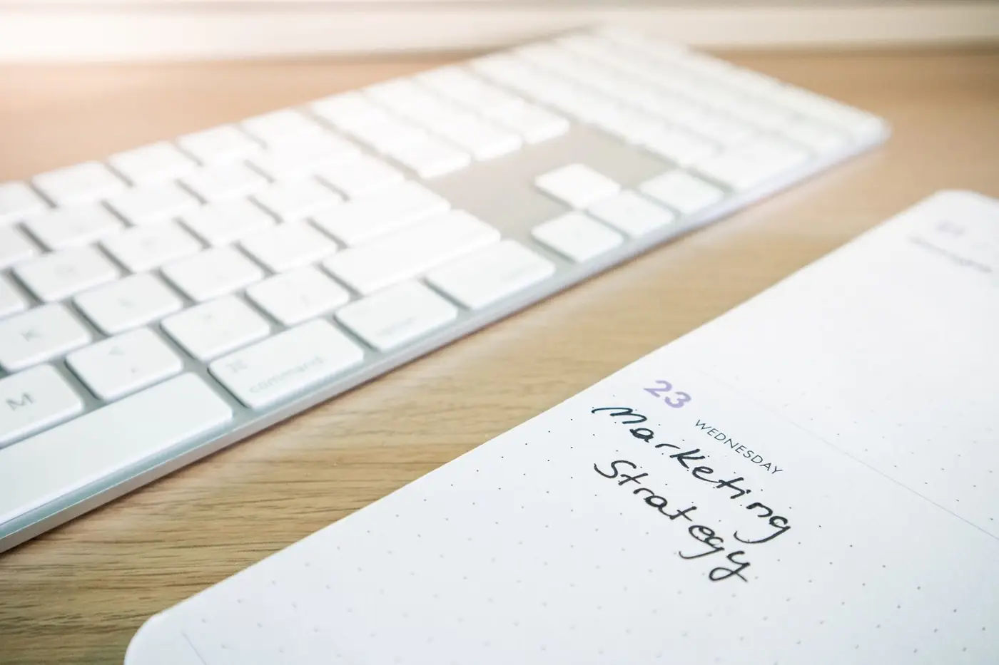 A planning notebook beside a keyboard on a desk